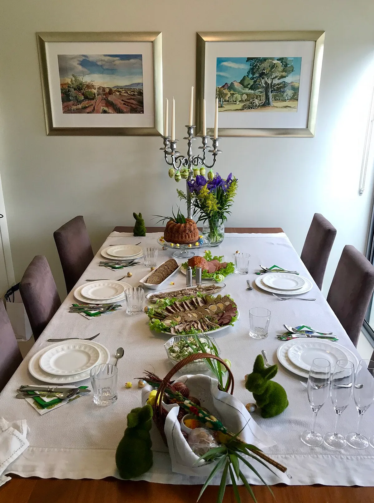 Osterbrunch-Tisch mit altem Geschirr und einem Kranz aus Zweigen