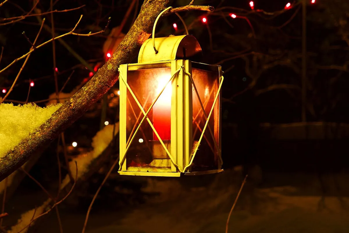 Gedeckter Gartentisch am Sommerabend mit Kerzenlicht und Emaillegeschirr