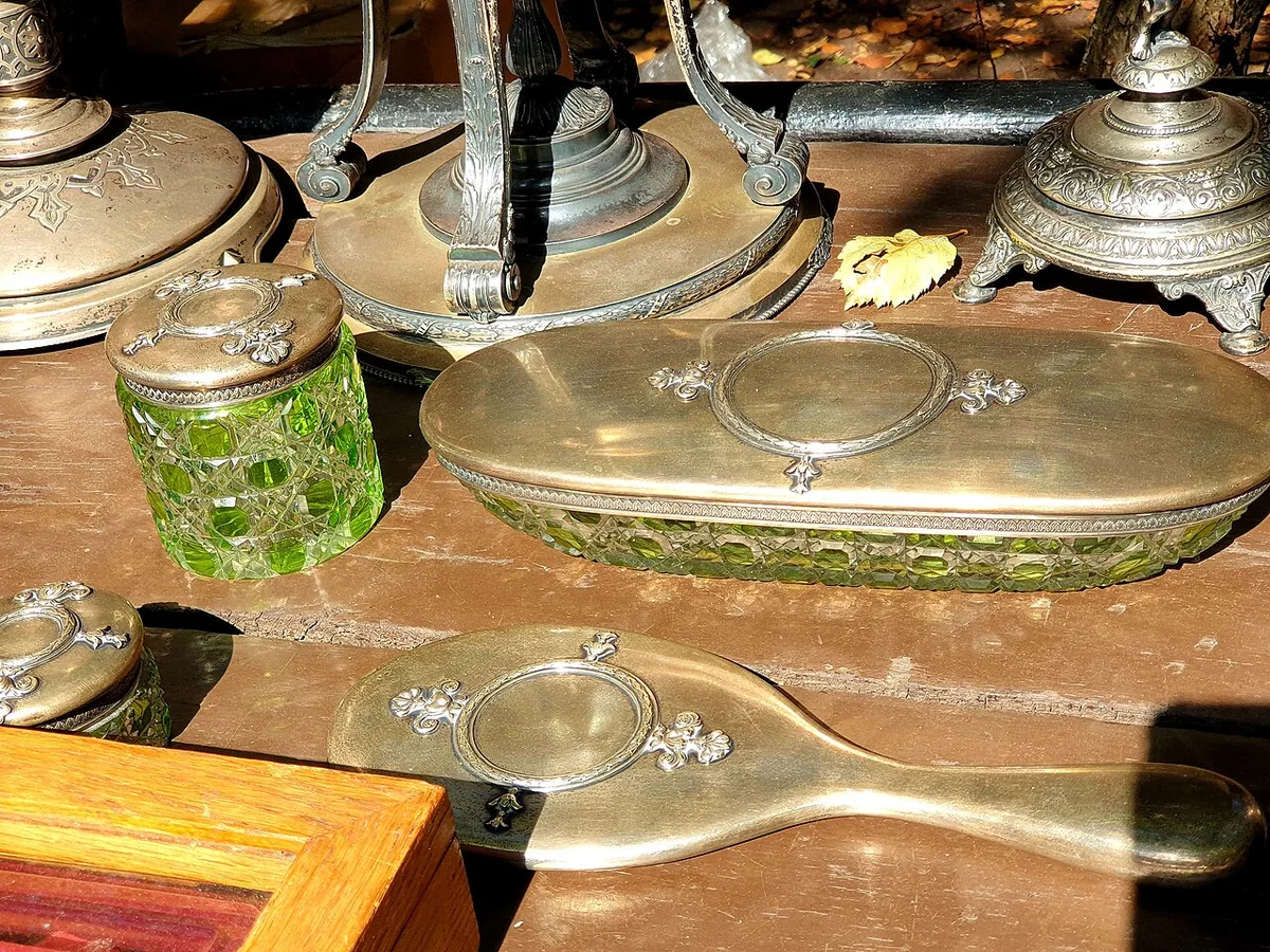 Antikes Silberset mit grünem Kristallglas auf einem Flohmarkttisch